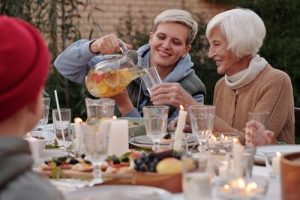 qualify for Medicaid, image of senior woman and younger woman dining outdoors with others